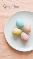 Pastel speckled Easter eggs in mint, yellow, pink, and peach on a white plate over soft linen, with Spring is Here handwritten text.