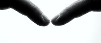 Two hands reaching toward each other in dramatic black and white lighting, symbolizing connection, unity, and human touch for emotional storytelling concepts.