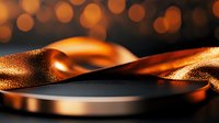 Elegant golden ribbon flowing gracefully over dark surface with warm bokeh lights creating luxurious atmosphere for premium branding and celebrations.