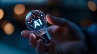 Glowing light bulb with AI text inside held by hand against dark background with bokeh lights, symbolizing artificial intelligence innovation and technology.