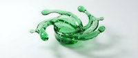 Green liquid splash with dynamic droplets and flowing motion creating abstract fluid art on white background for creative design projects.