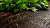 Fresh green parsley leaves scattered on dark rustic wooden table with copy space, natural food background for cooking and culinary design.