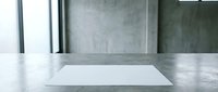 Blank white rectangular product display on gray concrete table with industrial window background, suitable for mockups and product presentations.