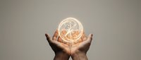 Hands holding glowing compass symbol representing direction, guidance and navigation in business strategy and decision making.