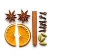 Aromatic winter spices arranged on white background including star anise, dried orange slices, cinnamon stick and cardamom pods for cooking and baking.