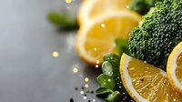 Fresh broccoli florets and lemon slices with water droplets on gray surface, ideal for healthy eating, nutrition, and food styling projects.