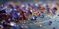 Macro view of purple amethyst crystals and gold glitter scattered on textured surface, creating luxurious gemstone composition for jewelry design.