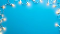 Glowing string lights creating decorative border frame on bright blue background, festive holiday illumination with copy space for seasonal designs.