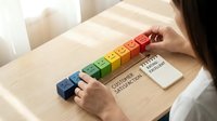 Woman arranging colorful wooden blocks showing customer satisfaction rating scale from poor to excellent on desk for business feedback survey.