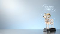 Goat figurine with golden horns on pedestal symbolizing new year 2027 celebration against soft blue background with copy space for holiday greeting cards and festive marketing materials.