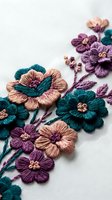 Colorful embroidered flowers with teal and purple thread on white fabric showcasing traditional needlework and textile art for crafting projects.