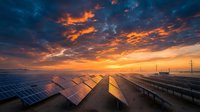 Young man with South Asian ethnicity wearing safety vest and hard hat, inspecting solar panels at industrial renewable energy facility during golden hour sunset, suitable for clean energy, sustainability, and industrial workforce concepts.