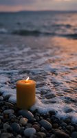 Burning candle on pebble beach at sunset creates peaceful atmosphere for meditation, relaxation and spiritual wellness concepts.