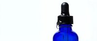 Cobalt blue glass dropper bottle with black pipette cap isolated on white background, ready for cosmetic, essential oil, serum, or pharmaceutical packaging design and branding projects.