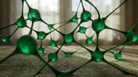 Green LED string lights with glowing bulbs on dark wire creating warm ambient lighting for holiday decoration and festive atmosphere indoors.