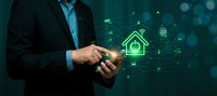 Businessman using smartphone with smart home technology interface and connected network icons for property management and automation control.