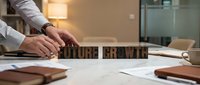Business professional arranging wooden letter blocks spelling FUTURE GROWTH on office desk with documents and modern workspace background for planning concepts.
