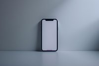 Modern smartphone with blank white screen standing upright against minimal gray background, clean mockup for app and interface design presentation.