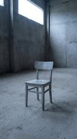 Solitary wooden chair in empty concrete room with natural light from window, conveying abandonment, isolation, and minimalist industrial aesthetics for conceptual projects.