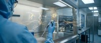 Scientist in protective gear working with molecular structures in modern laboratory biosafety cabinet for pharmaceutical research and development.