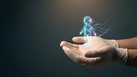 Hands holding glowing holographic human figure with energy connections representing digital healthcare, telemedicine, and futuristic medical technology concepts.