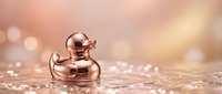 Luxury rose gold rubber duck floating on sparkling water surface with elegant bokeh lighting effects creating premium spa atmosphere for relaxation concepts.