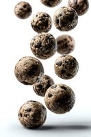 Falling chocolate protein energy balls with nuts and seeds isolated on white background for healthy snacking and fitness nutrition concepts.