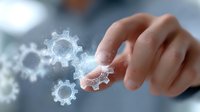 Hand touching glowing digital gears in virtual space, illustrating technological innovation and business process automation against blurred background.