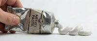 Overturned jar of argyle paste spilling white decorative elements onto white surface, isolated on white background for design and craft projects.