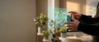 Businessman hands holding smartphone with glowing green recycling symbol hologram in modern office environment promoting sustainable business practices.