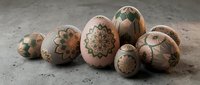 Hand-painted Easter eggs with intricate floral patterns and geometric designs on neutral background for spring holiday decorations and crafts.