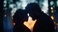 Romantic silhouette of young couple about to kiss against glowing sunset bokeh background, intimate moment captured in dreamy atmospheric lighting.