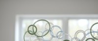 Modern abstract circles pattern with overlapping rings in soft green and blue tones on light background for contemporary interior design and decor.