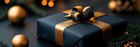 Elegant black gift box with bronze ribbon and decorative bow surrounded by golden ornaments and pine branches for holiday celebrations and special occasions.