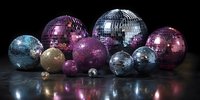 Collection of colorful disco balls in various sizes, including silver, purple, and gold, arranged on reflective dark surface for party decoration.