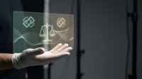 Legal services and compliance concept with hand holding transparent digital display showing scales of justice, property and financial icons with glowing neon lines.