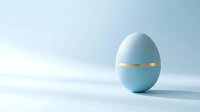 Light blue Easter egg with golden band on clean white background for spring holiday decorations and greeting cards.
