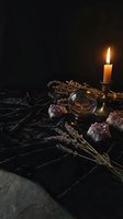 Mystical altar setup with burning candle, amethyst crystals, brass bowl and dried herbs on dark stone surface for spiritual rituals and meditation practices.