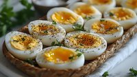 Soft boiled eggs seasoned with herbs and spices on woven serving tray, garnished with fresh parsley. Close up view of gourmet appetizer preparation.