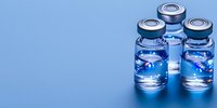 Medical vials with aluminum cap and clear liquid on blue background, pharmaceutical glass containers for vaccine or medicine, healthcare concept.