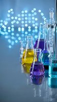Laboratory glassware with colorful chemical solutions on reflective surface against blue bokeh background for scientific research and education.