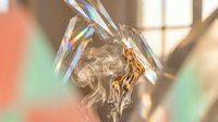 Professional woman with blonde hair in elegant crystal prism light effect with rainbow reflections and artistic smoke patterns in modern office setting.