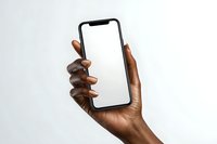 Close-up of dark-skinned hand holding modern smartphone with blank white screen against neutral background. Perfect for tech mockups and digital presentations.