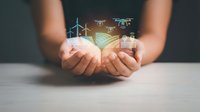 Cupped hands holding holographic renewable energy icons including wind turbines and drones representing sustainable technology and green innovation concepts.