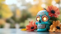 Decorative turquoise sugar skull with glowing eyes surrounded by orange and yellow flowers on blurred natural background. Day of Dead celebration concept.