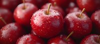 Fresh ripe red apples with water drops on glossy skin, macro close up view showing natural texture and dewdrops in bright lighting.