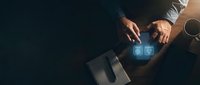 Professional businessman hands touching digital holographic email and phone icons on dark wooden desk with laptop and coffee cup for modern communication.