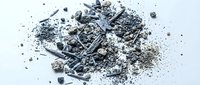 Pile of crushed charcoal and ash fragments scattered on white background, suitable for environmental, industrial, or educational content about combustion and waste materials.