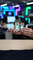 Female hands holding wooden animal figurines bear owl fox in modern tech office with colorful neon lighting background for creative workspace decor.