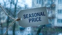 Seasonal price tag hanging against a rain-covered window, symbolizing dynamic pricing, sales strategy, and weather-related discount concepts.